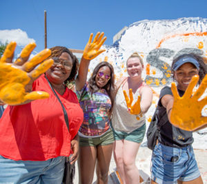 students putting handprints on the rock