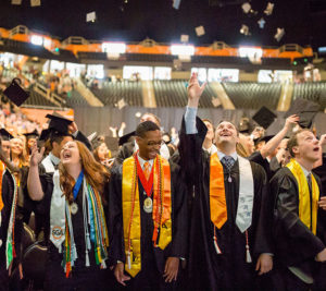 students throwing mortar boards at commencement